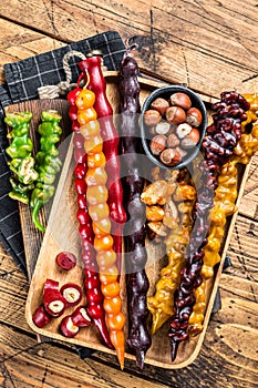 Colored Churchkhela Georgian sweets with Walnuts and hazelnuts. Wooden background. Top view