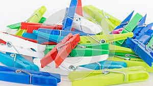 Colored clothes pegs on a white isolated surfaces