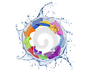 Colored clothes rotates in a swirling splashes of water on white photo