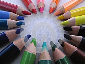 Colored crayons lined up in a circle on a white background.