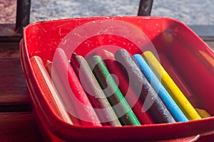 colored crayons, various colors of crayons on a wooden table with natural light and background window, diversity