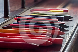 colored crayons, various colors of crayons on a wooden table with natural light and background window, diversity