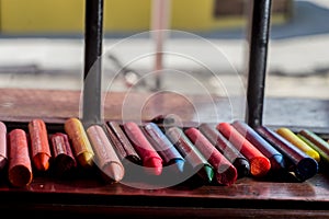 colored crayons, various colors of crayons on a wooden table with natural light and background window, diversity