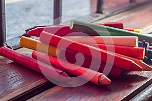 colored crayons, various colors of crayons on a wooden table with natural light and background window, diversity