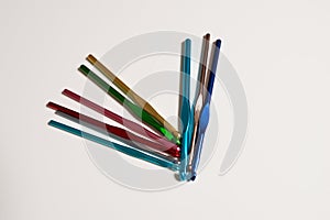 colored crochet hooks on white background