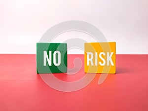 Colored cube with the word NO RISK on a white and red background.