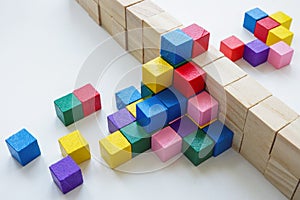 Colored cubes overcome an obstacle in the form of a wall. Creativity or diversity and inclusion concept. photo