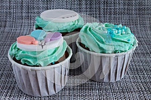 Colored cupcakes close-up on grey fabric background