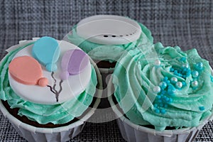 Colored cupcakes close-up on grey fabric background