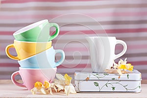 Colored cups with a pitcher and daffodils vintage retro
