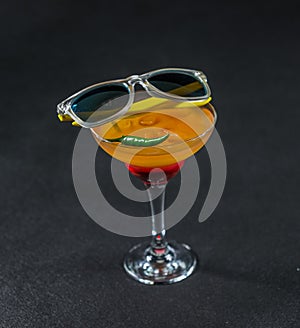 Colored drink, a combination of red orange, lemon, martini glass
