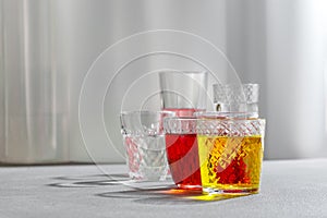 Colored drinks in glass cups on a gray background