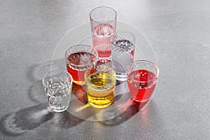 Colored drinks in glass cups on a gray stone table