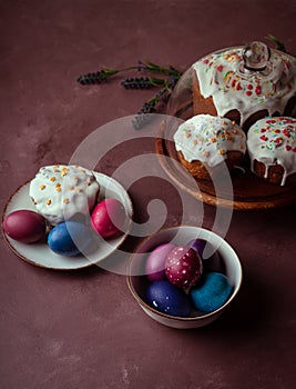 Colored Easter eggs, cakes on dark purple background