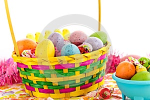 Colored Easter eggs, chicks, candy and basket