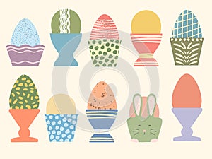 Colored Easter eggs in cute cups vector illustration set. Eggs decorated with brush strokes and dots on pastel