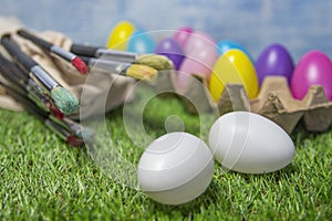 Colored Easter eggs in egg carton on grass