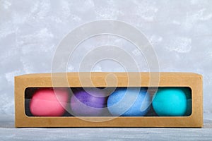 Colored Easter eggs in a gift box on a gray concrete background.