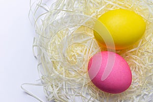 Colored Easter eggs in nest isolated on white background.