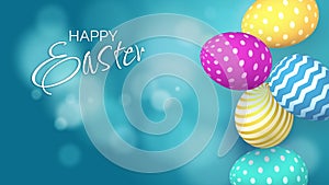 Colored Easter eggs with patterns fall down. Blue background with bokeh and the inscription Happy Easter.