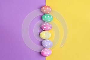 Colored Easter eggs on purple and yellow background.
