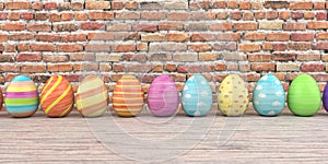 Colored easter eggs on the wooden table and brick wall in the background.