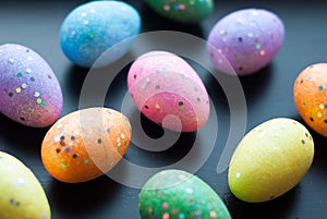 Colored eggs on black background,