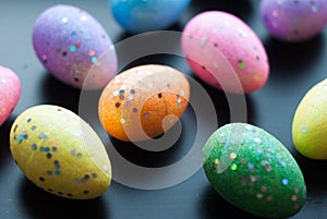 Colored eggs on black background,