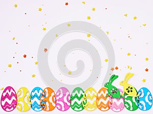 Colored eggs composition flat lay on white background, close up. Easter composition