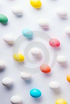 Colored eggs flat lay on a white background. Easter and spring composition.