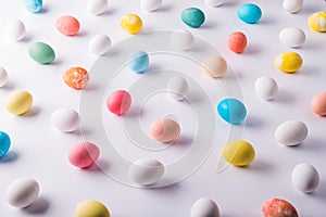 Colored eggs flat lay on a white background. Easter and spring composition.