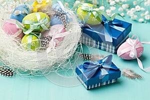 Colored eggs in the nest and presents in blue boxes