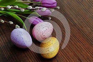 Colored eggs with tulips on wooden background. Easter, Spring holidays