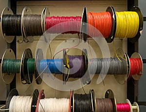 Colored electrical wires on spools on rack