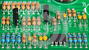 Colored electronic components. Resistors, transistors, capacitors and integrated circuit on PCB