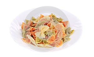 Colored farfalle on white plate.