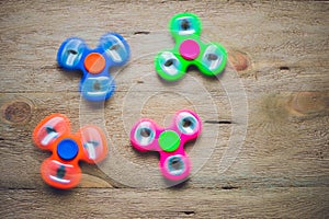 Colored fidget spinners stress relieving toy on wooden background