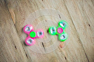 Colored fidget spinners stress relieving toy on wooden background