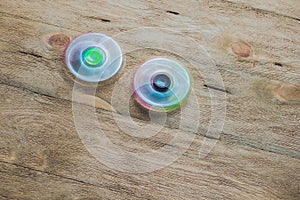 Colored fidget spinners stress relieving toy on wooden background