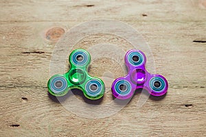 Colored fidget spinners stress relieving toy on wooden background