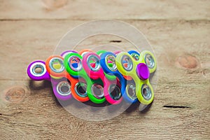 Colored fidget spinners stress relieving toy on wooden background