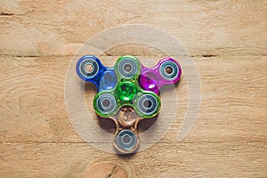 Colored fidget spinners stress relieving toy on wooden background