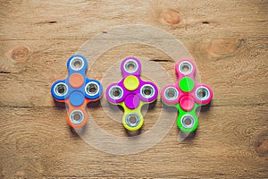 Colored fidget spinners stress relieving toy on wooden background