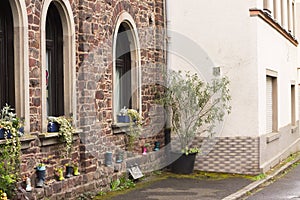 Colored garden boots in front of a brick house Moselkern, Germany