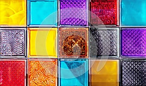 Colored glass blocks with embossed patterns. Multi-colored glass squares.