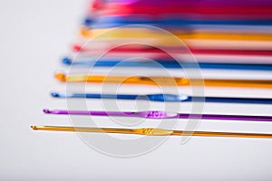 Colored hooks for wool knitting on white background.