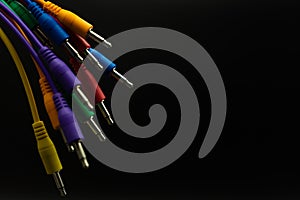 Colored jack cables on black insulated background, selected focus, Copy paste, Music concept