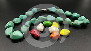 Colored jewelry and mineral stones on a black background. Turquoise nacklace