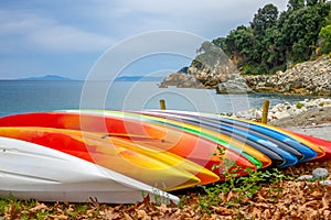 Colored Kayaks on the Shore of a Summer Bay