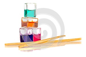 Colored liquid containers next to chinese sticks isolated on white